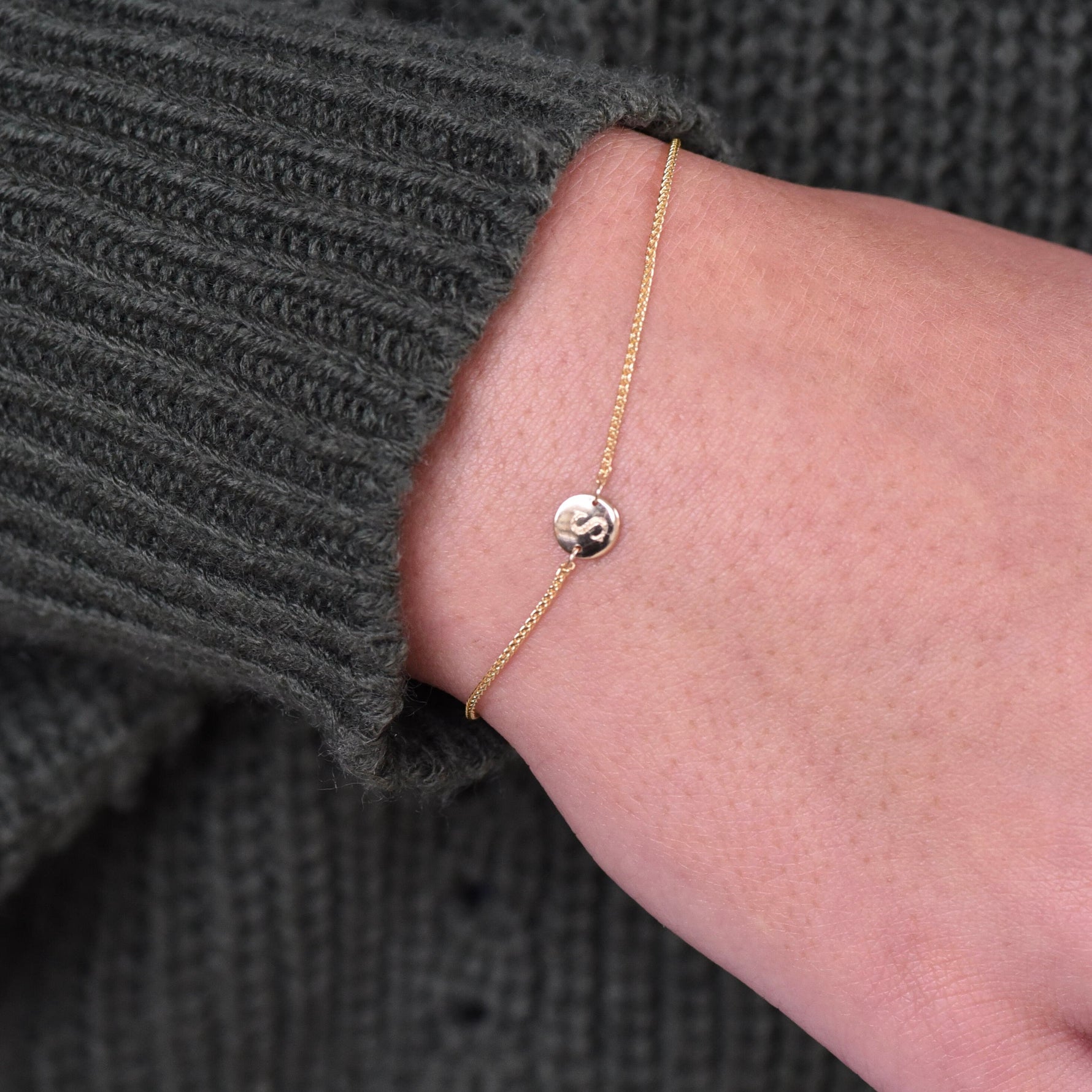 14K gold tiny initial bracelet with personalized letter charm, solid gold jewelry by Sash Jewelry, featuring delicate chain and initial pendant.