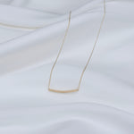 Gold necklace on a white fabric background