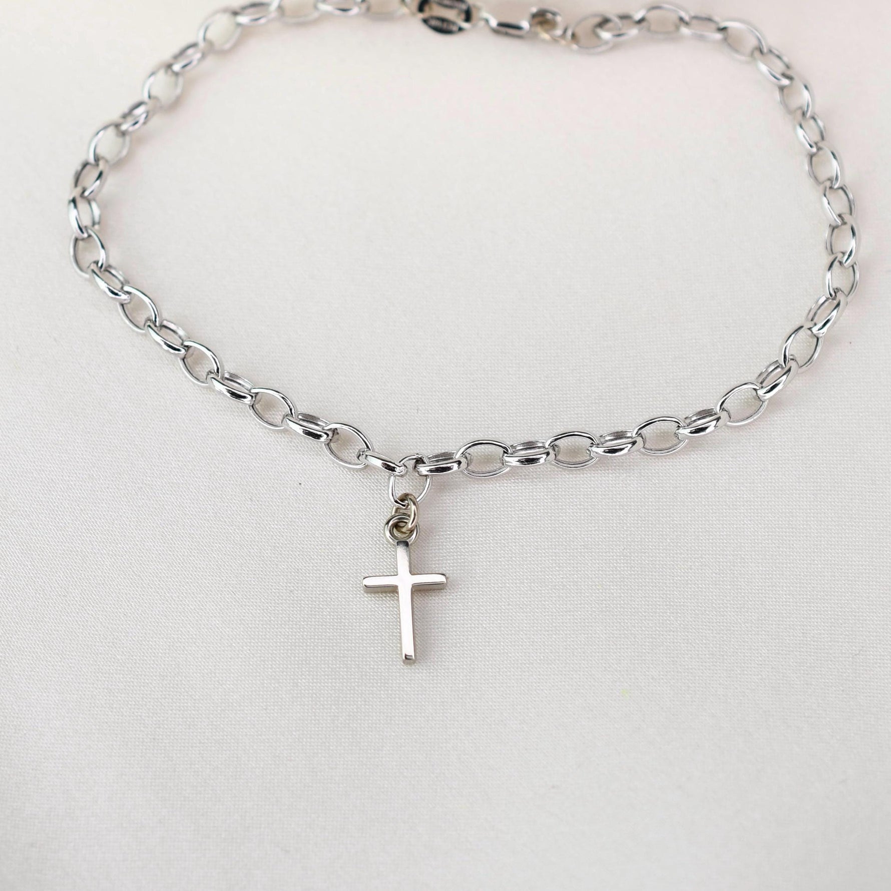 This elegant 14K white gold cross bracelet features a delicate 3.2mm rolo chain and a small cross charm, creating a timeless piece that symbolizes faith and style.