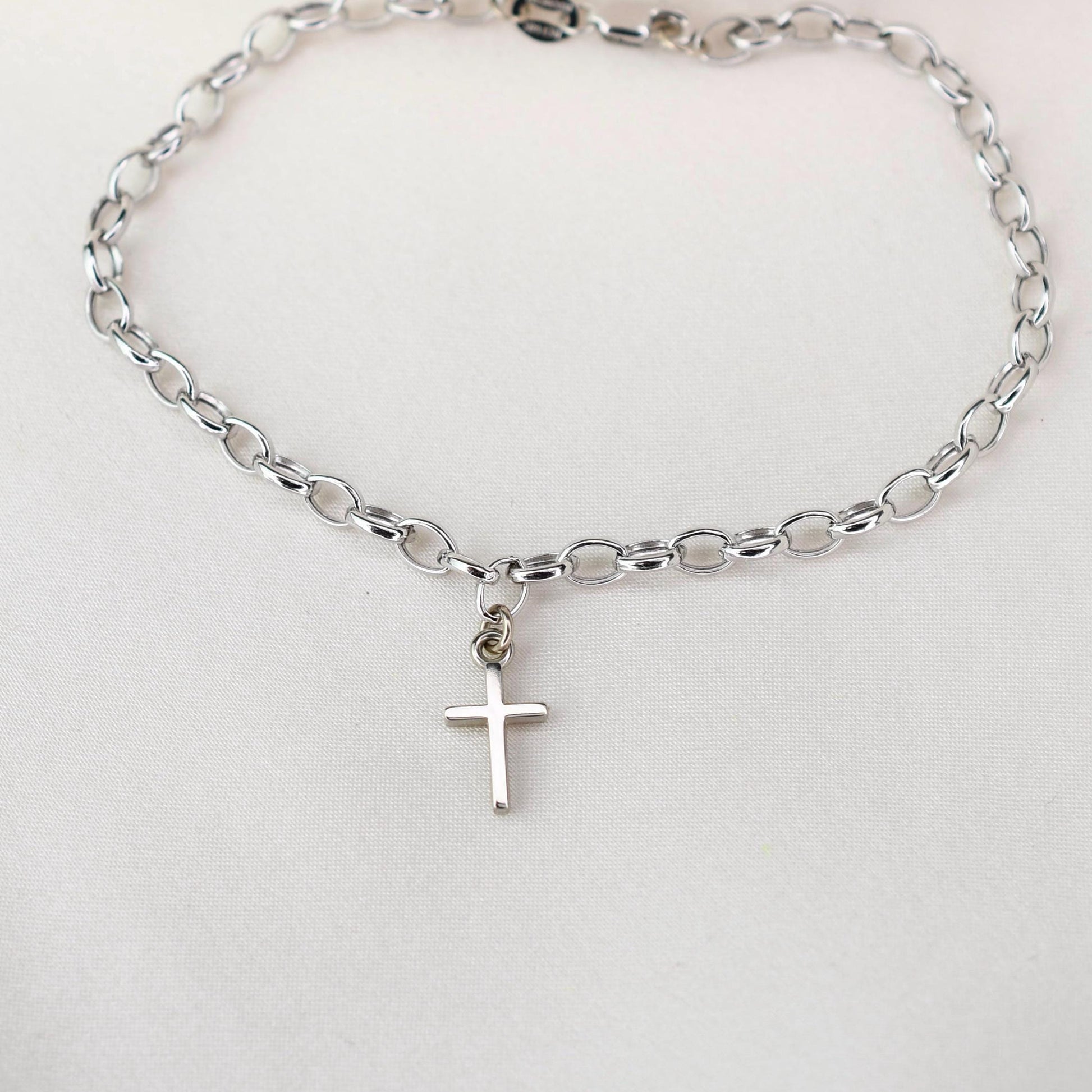 This elegant 14K white gold cross bracelet features a delicate 3.2mm rolo chain and a small cross charm, creating a timeless piece that symbolizes faith and style.
