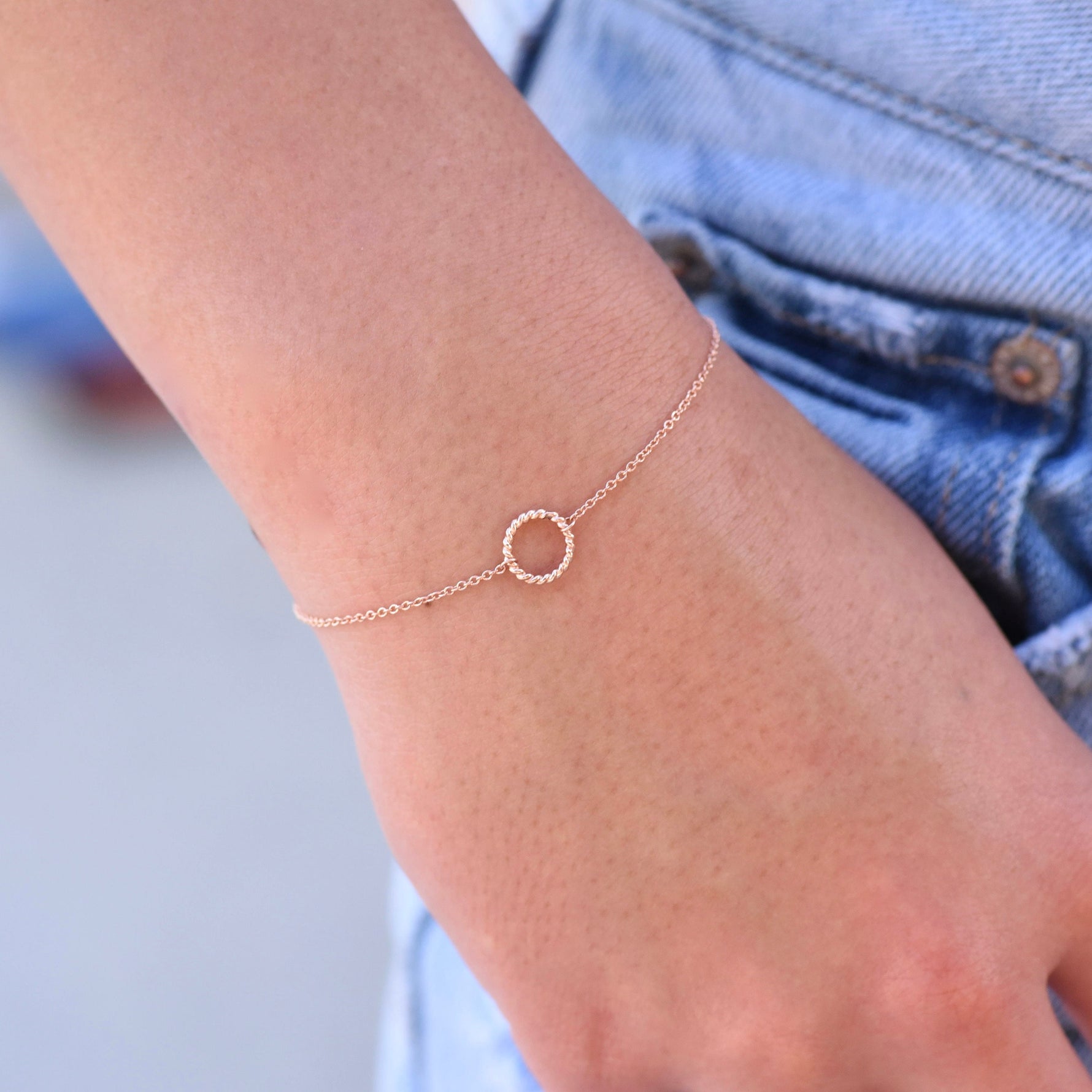 Rose gold bracelet on a wrist with a blurred background