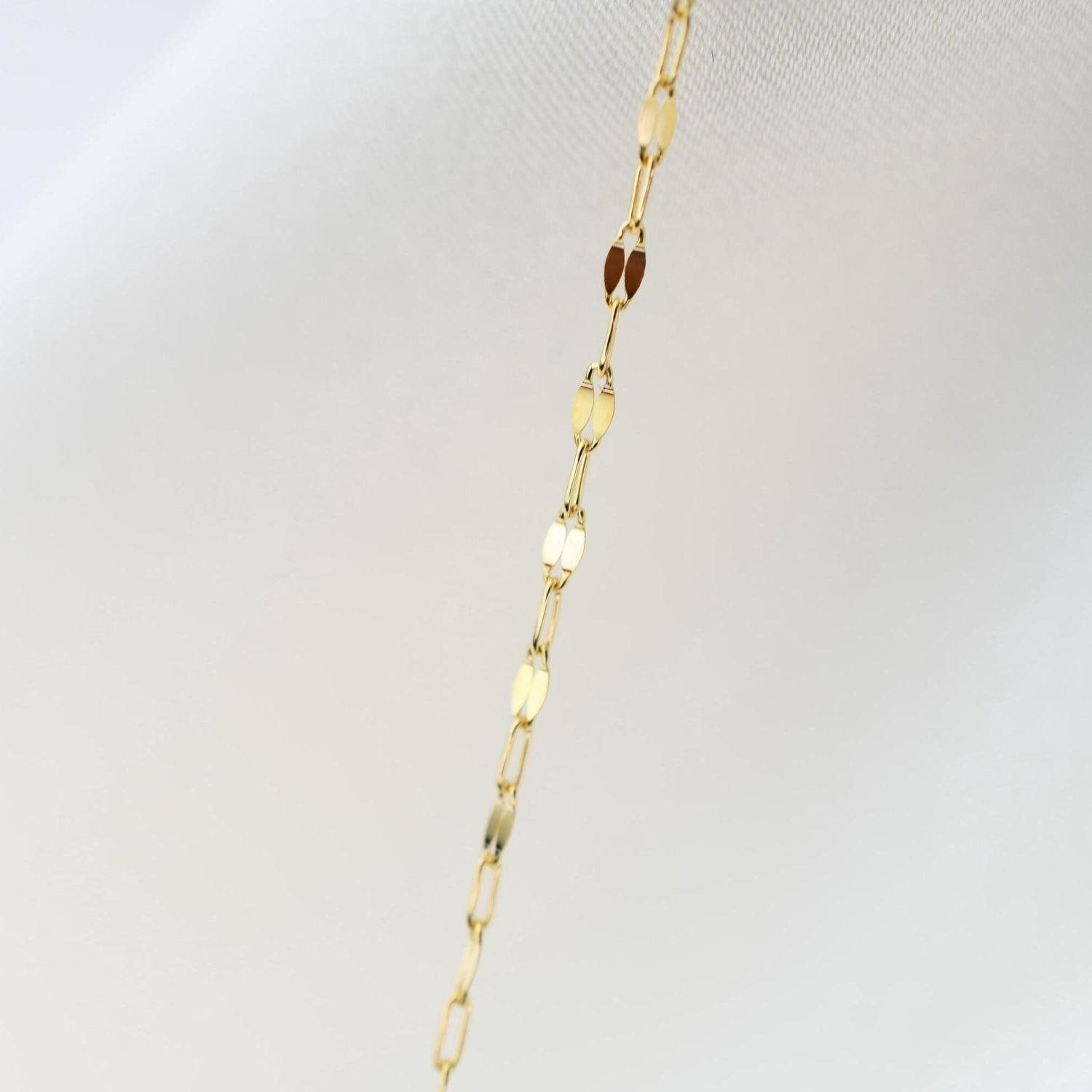 Delicate 14K gold necklace by Sash Jewelry featuring a thin chain and minimalist design, close-up view of the jewelry.