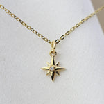 Gold necklace with a star-shaped pendant on a white background