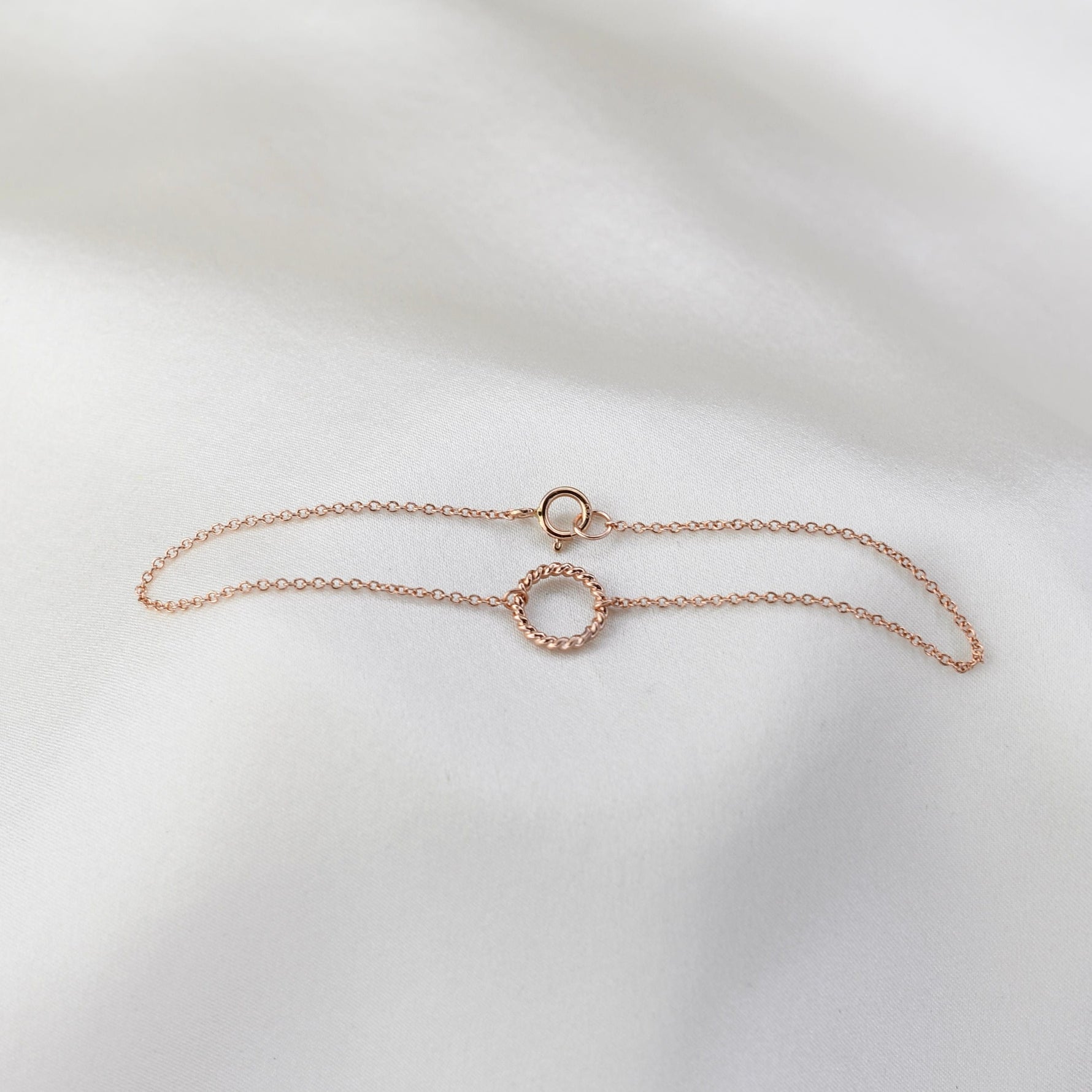 Rose gold bracelet on a light gray background