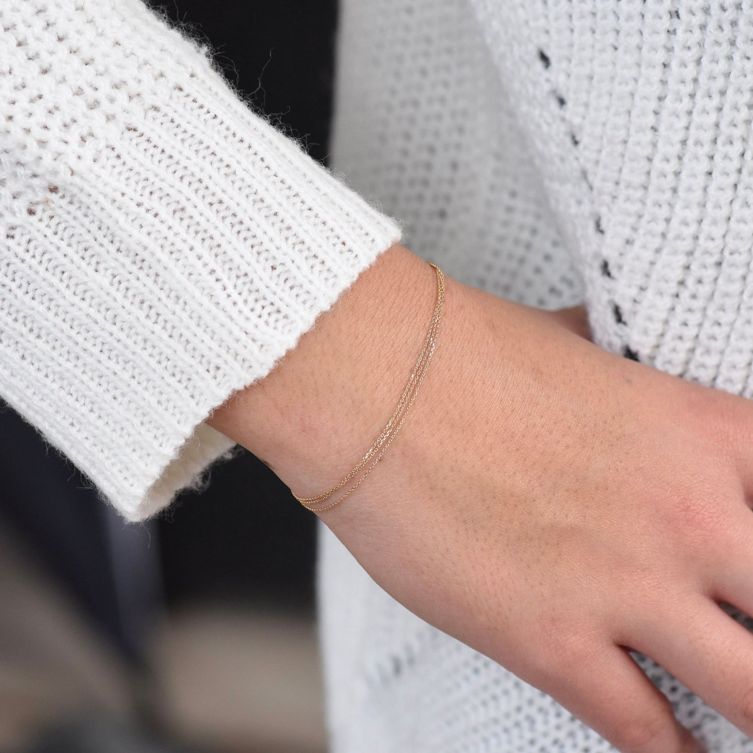 Gold bracelet on a wrist with a blurred background