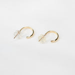 14K gold hoop earrings by Sash Jewelry featuring minimalist solid gold design for everyday wear, shown on a white background.