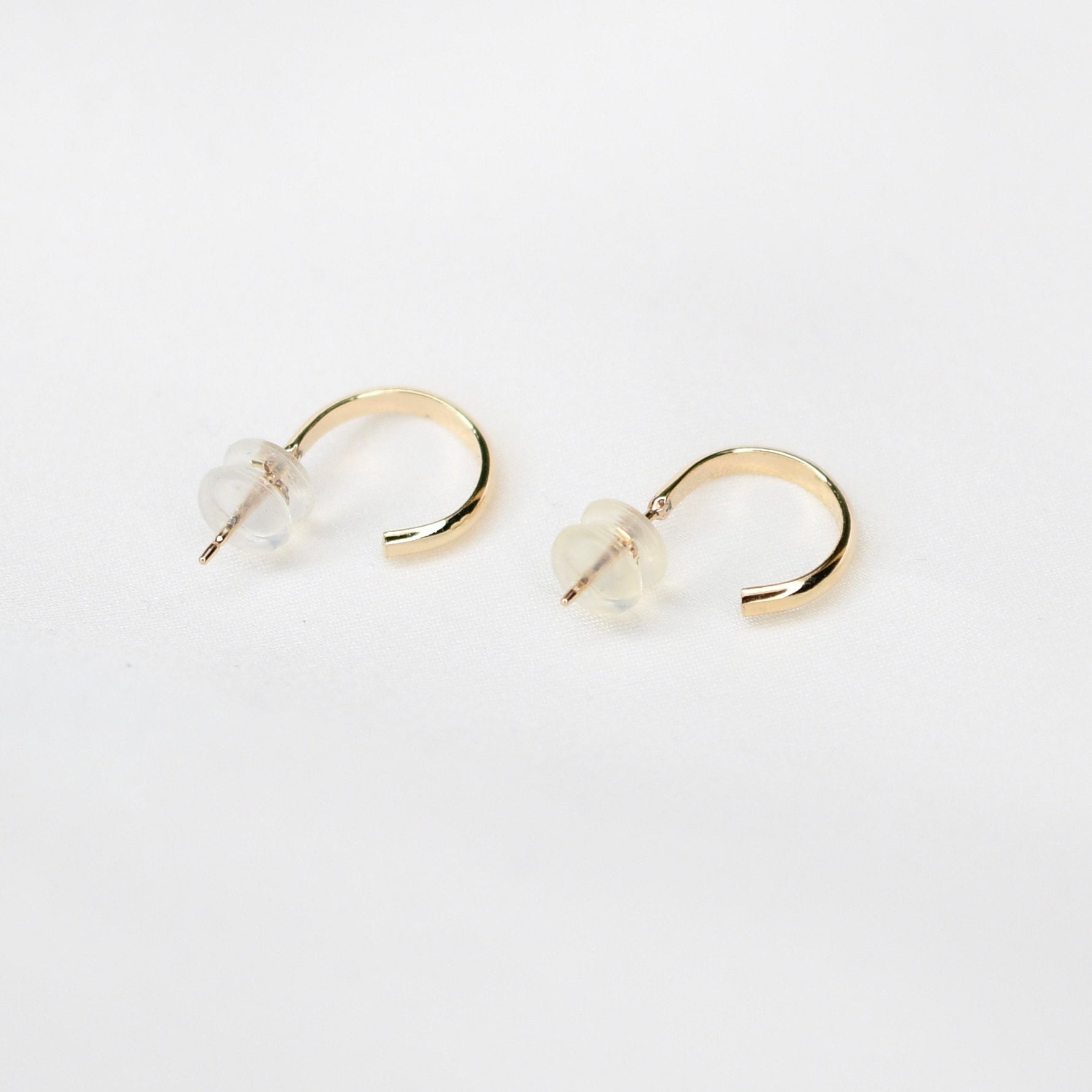 14K gold hoop earrings by Sash Jewelry featuring minimalist solid gold design for everyday wear, shown on a white background.
