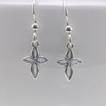 Silver flower-shaped earrings on a light gray background