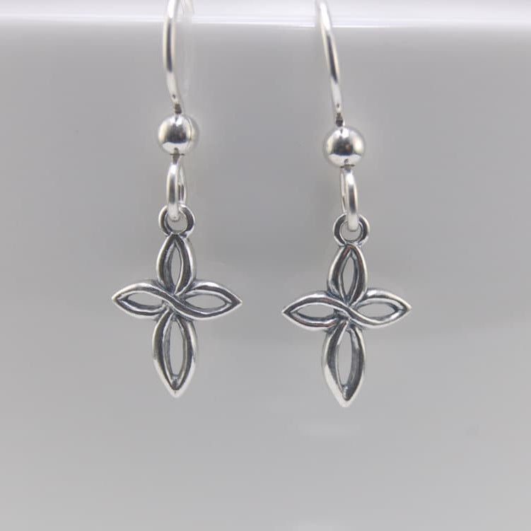Silver flower-shaped earrings on a light gray background