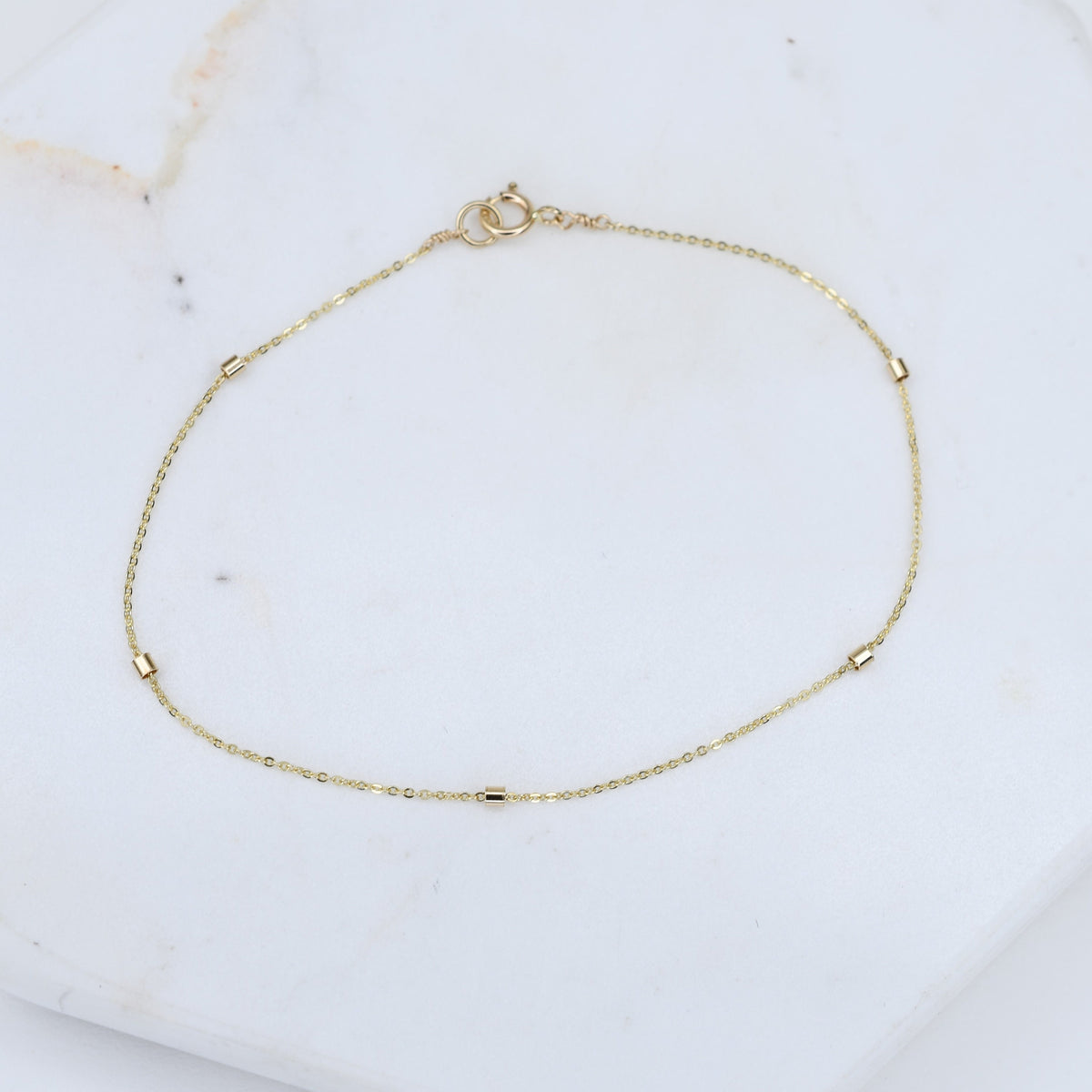 14K gold dainty chain bracelet with 1.5mm beads from Sash Jewelry, featuring a thin, elegant gold bracelet design.