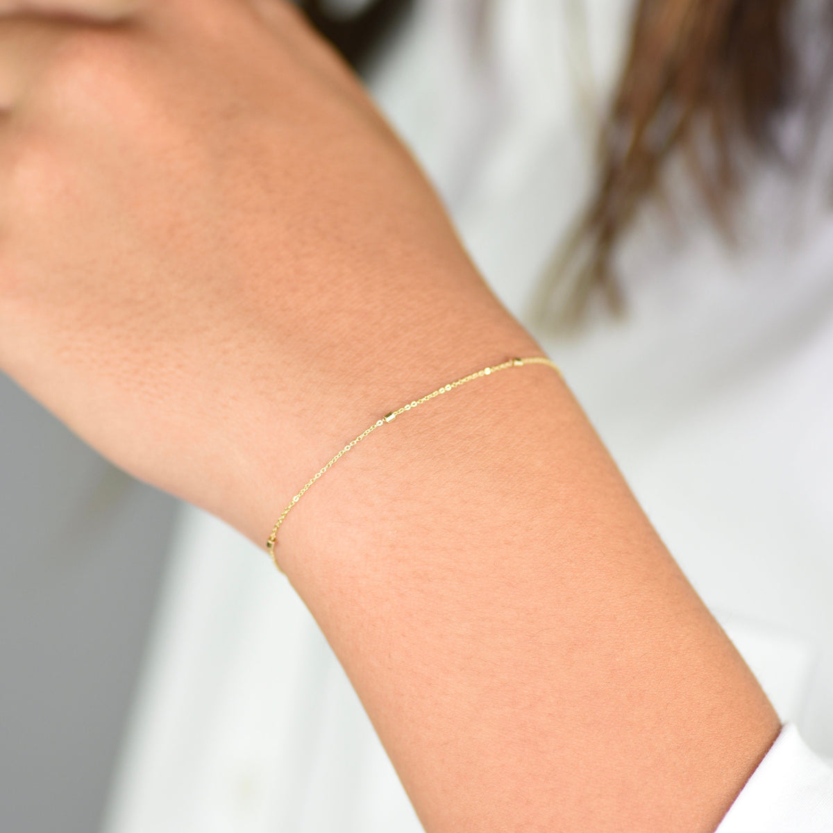 14K gold dainty chain bracelet by Sash Jewelry with 1.5mm bead design and thin, elegant link for a delicate jewelry look.