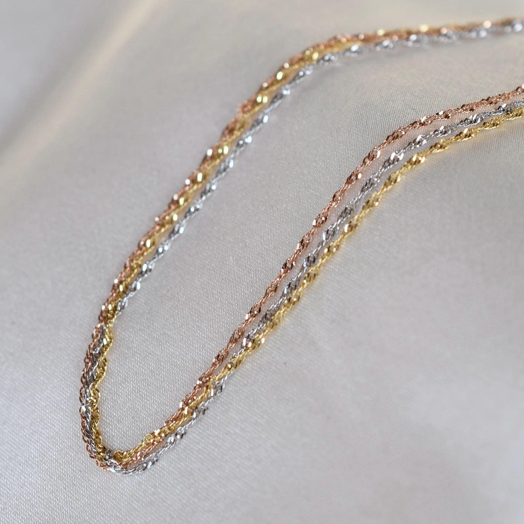 14K gold dainty tri-color Singapore chain bracelet with sparkling accents, designed by Sash Jewelry.
