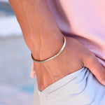 Gold bracelet on a wrist with a blurred background