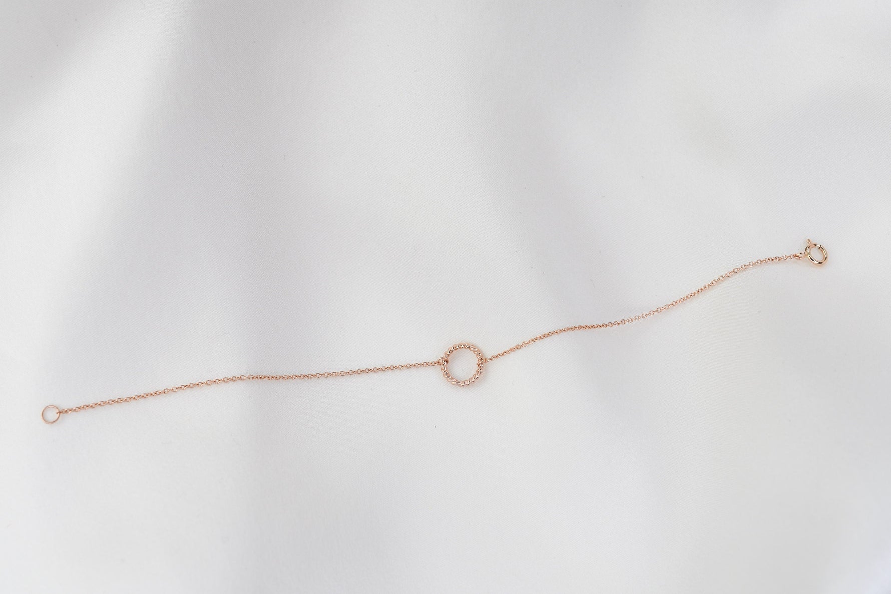 Rose gold bracelet on a light gray background