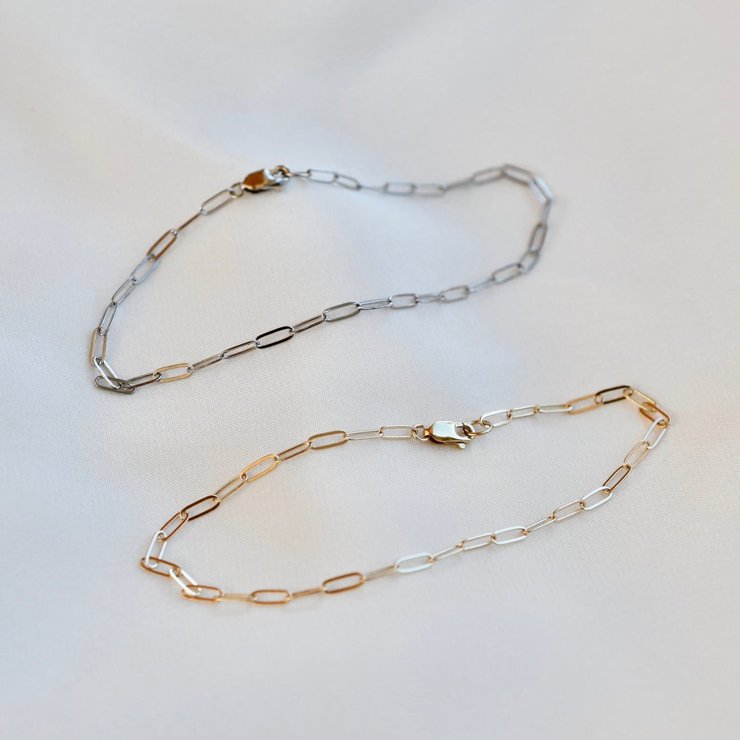 Dainty 14K solid gold flat paper clip bracelet in yellow or white gold. 2mm chain + rectangle lobster clasp. Perfect for stacking or daily wear. Sizes .6"–8.5".