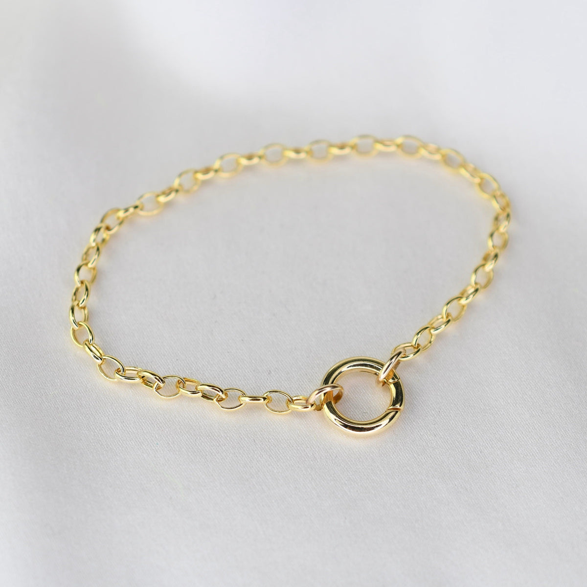 14K gold charm holder bracelet with rolo chain and hinged bail by Sash Jewelry, featuring a polished gold finish and clasp detail.