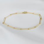Gold chain necklace on a light gray background