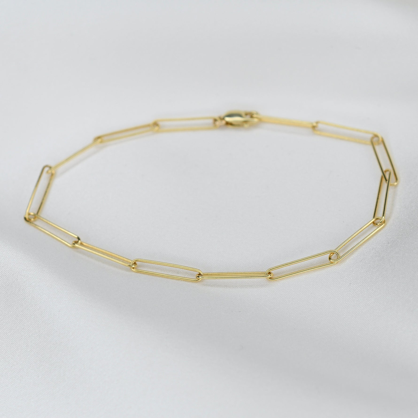 Gold chain necklace on a light gray background