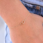 Gold anklet on a person's ankle with a blurred background