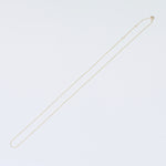 Gold necklace on a light gray background