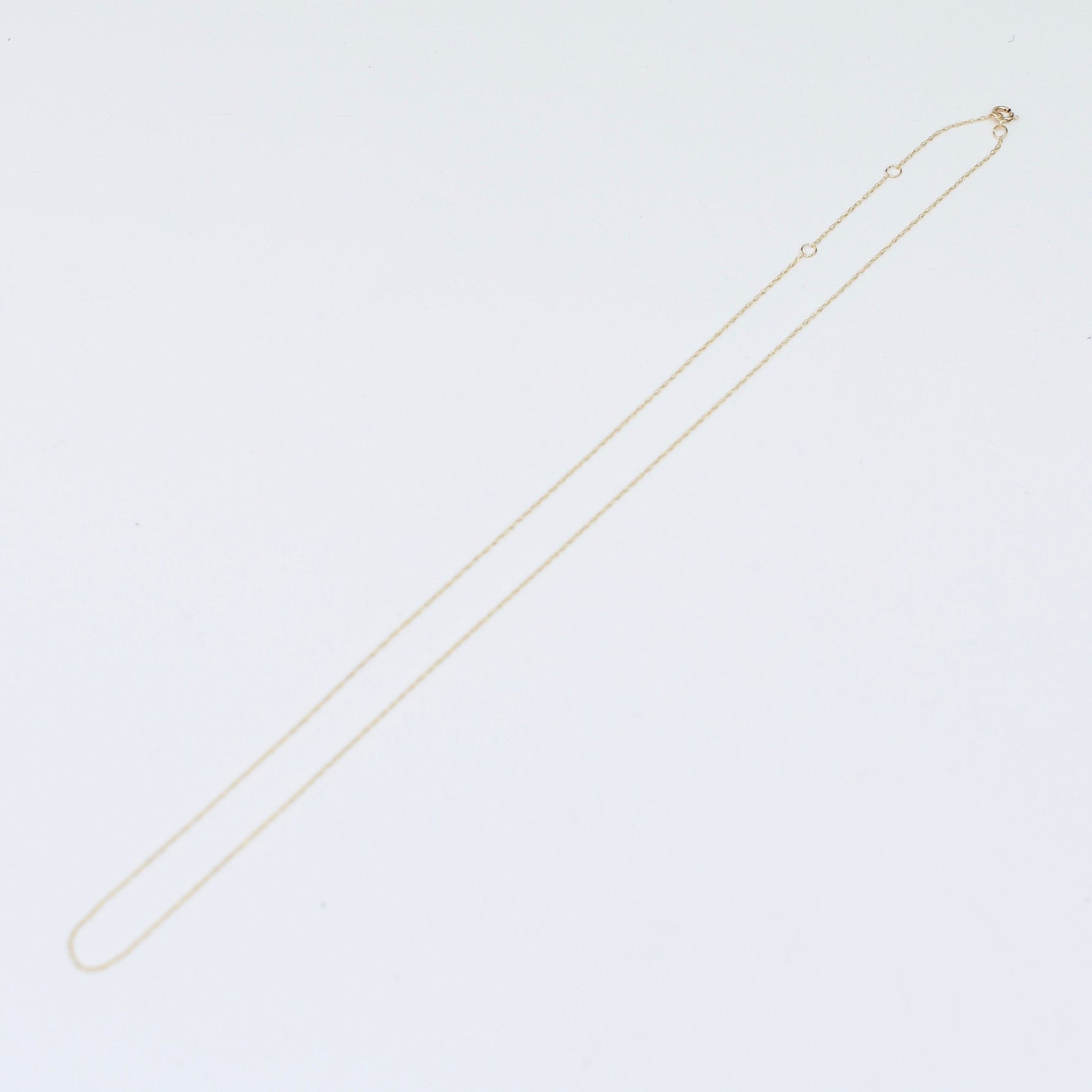 Gold necklace on a light gray background