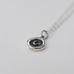 Silver necklace with a pendant on a light gray background