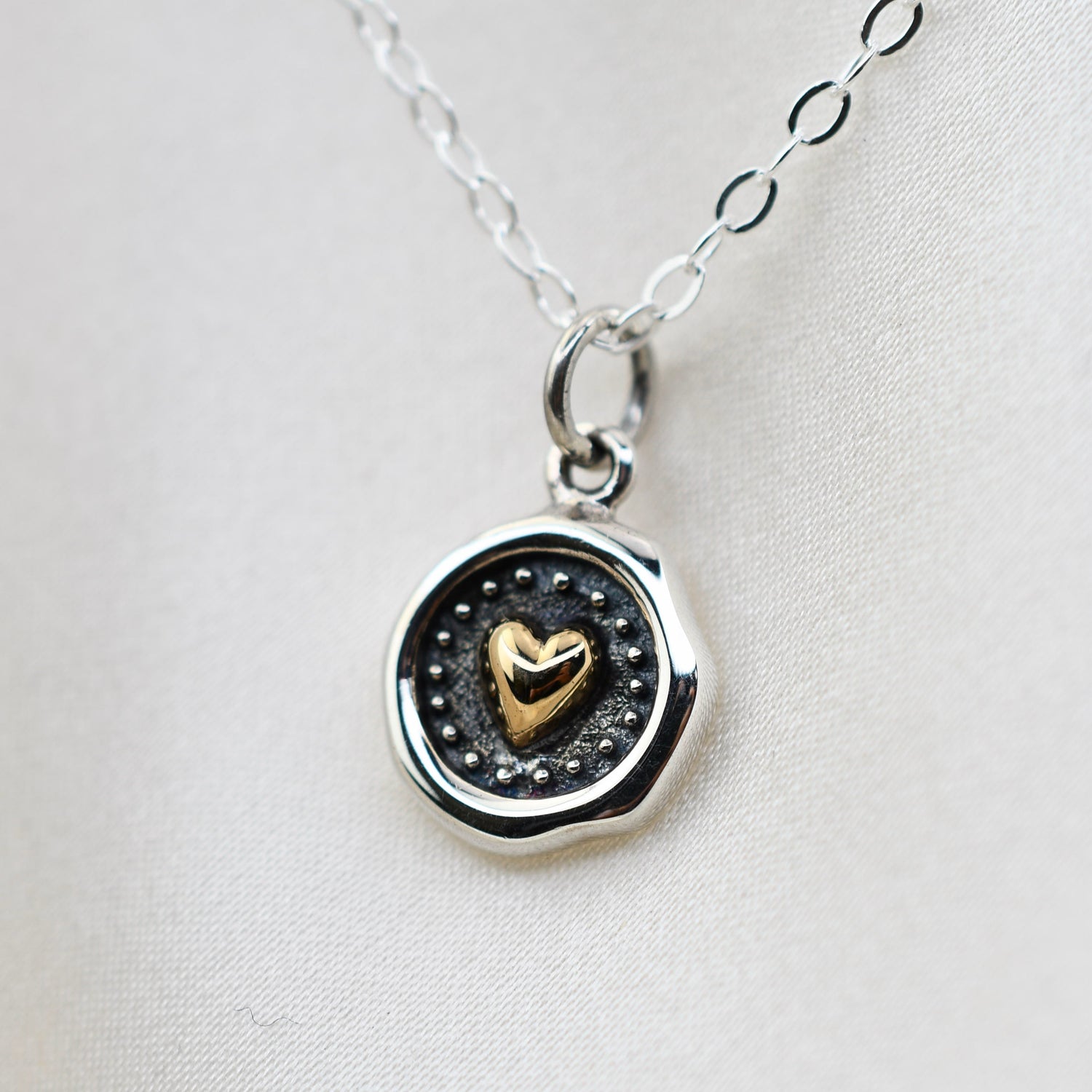 Sterling silver and bronze small heart necklace with wax seal heart charm, featuring a delicate chain and detailed pendant.