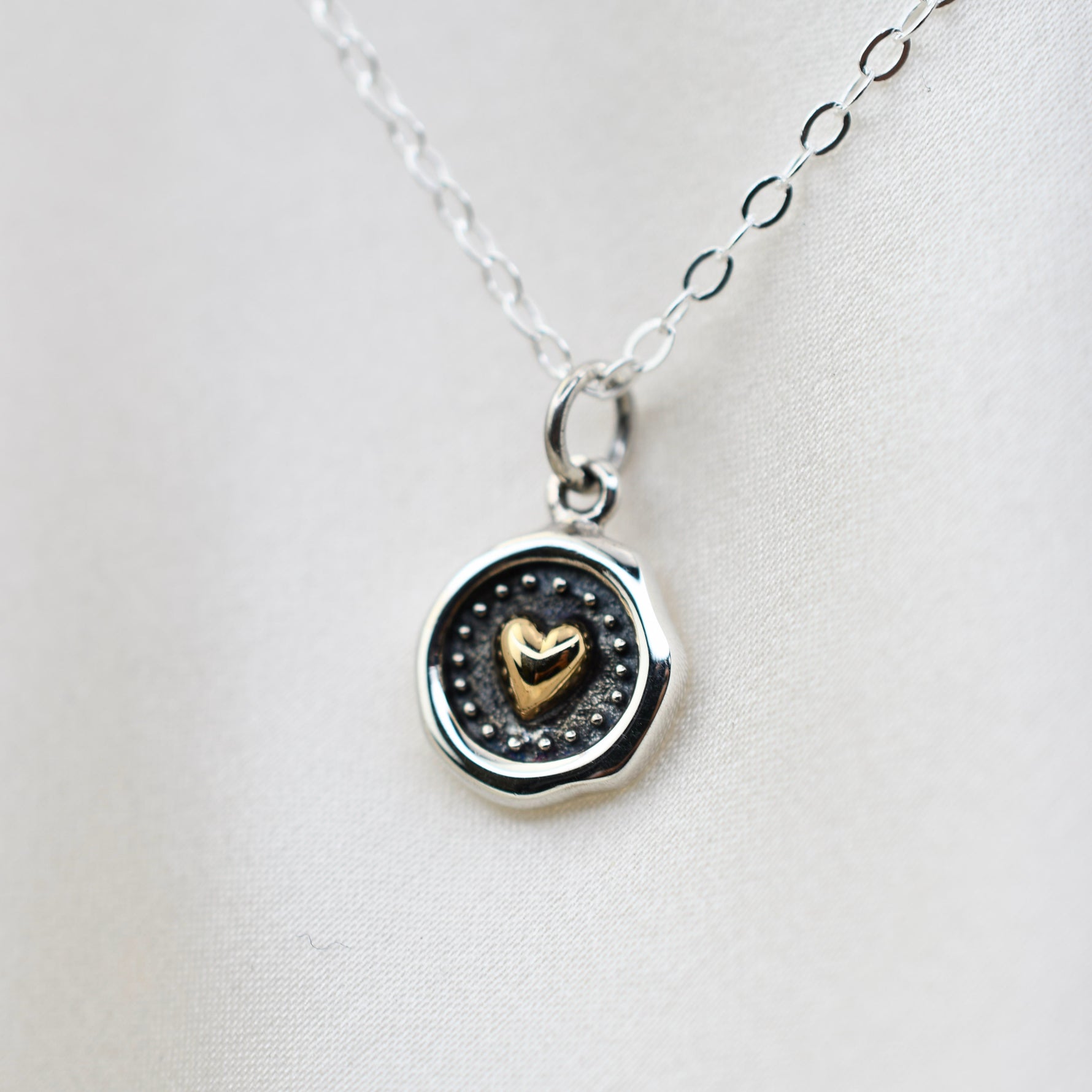 Sterling silver and bronze small heart necklace with wax seal heart charm by Sash Jewelry, featuring detailed metalwork and delicate chain.