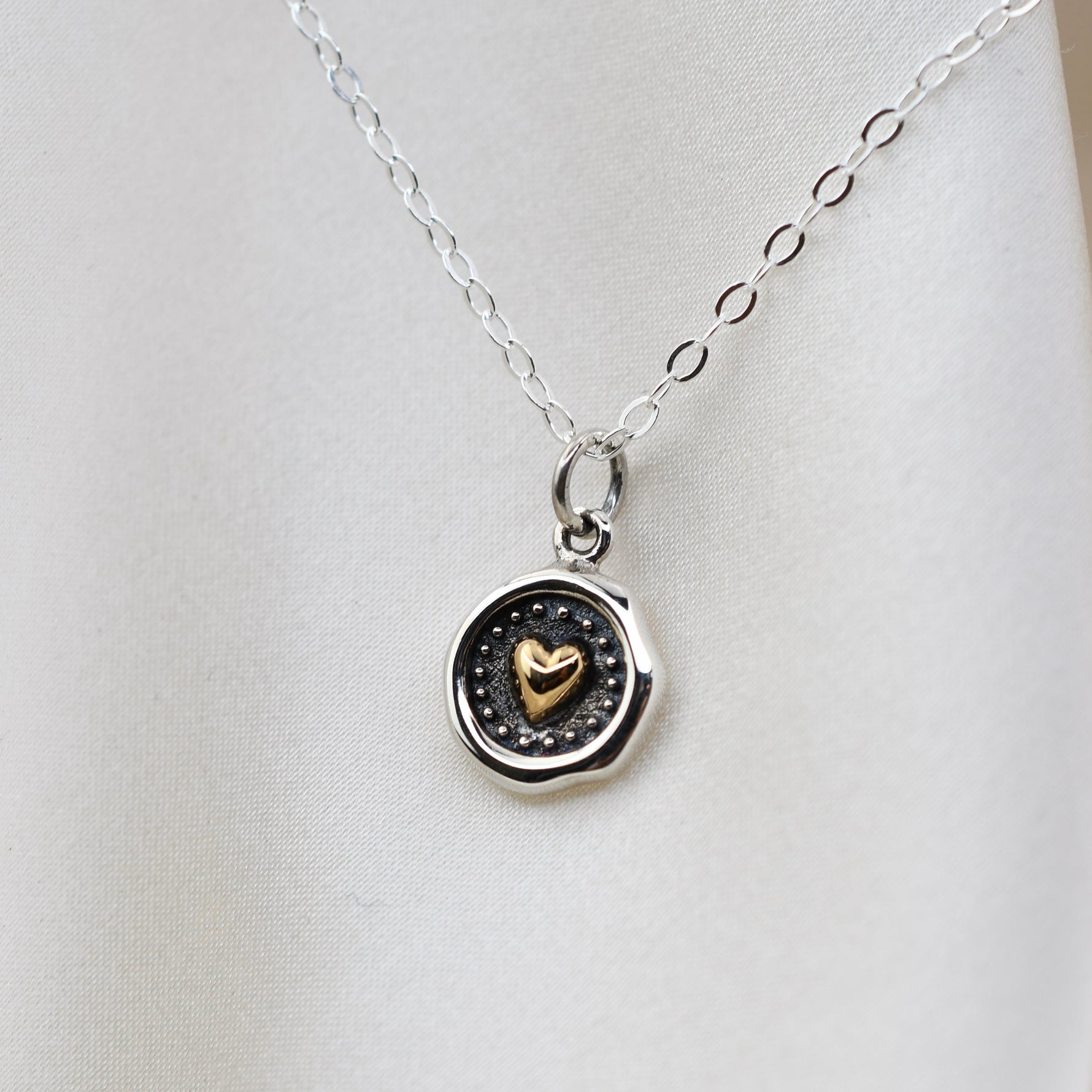 Sterling silver and bronze small heart necklace with wax seal heart charm, featuring delicate chain and detailed design.