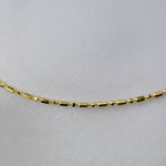 Gold necklace on a light gray background