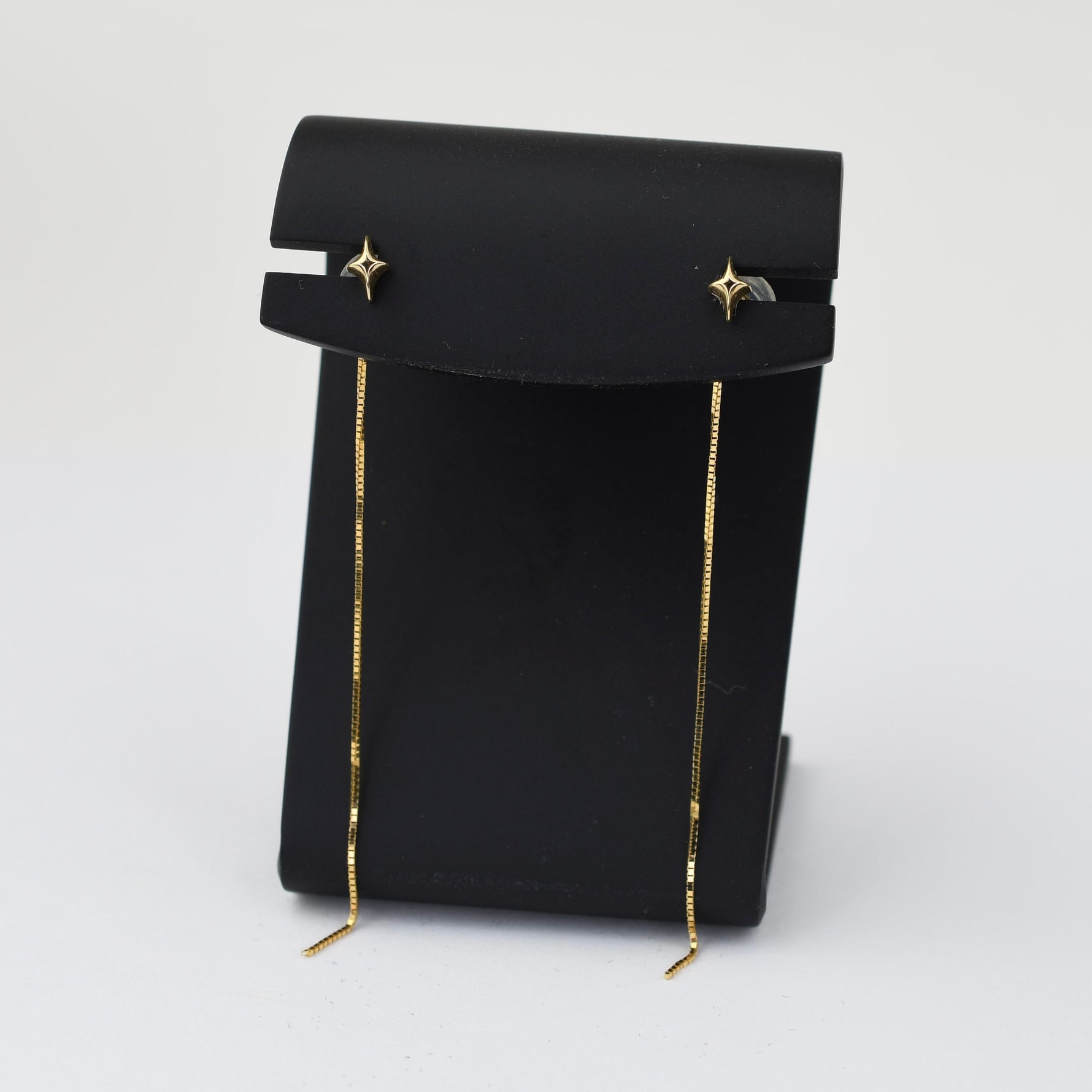 Black pouch with gold drawstring on a white background