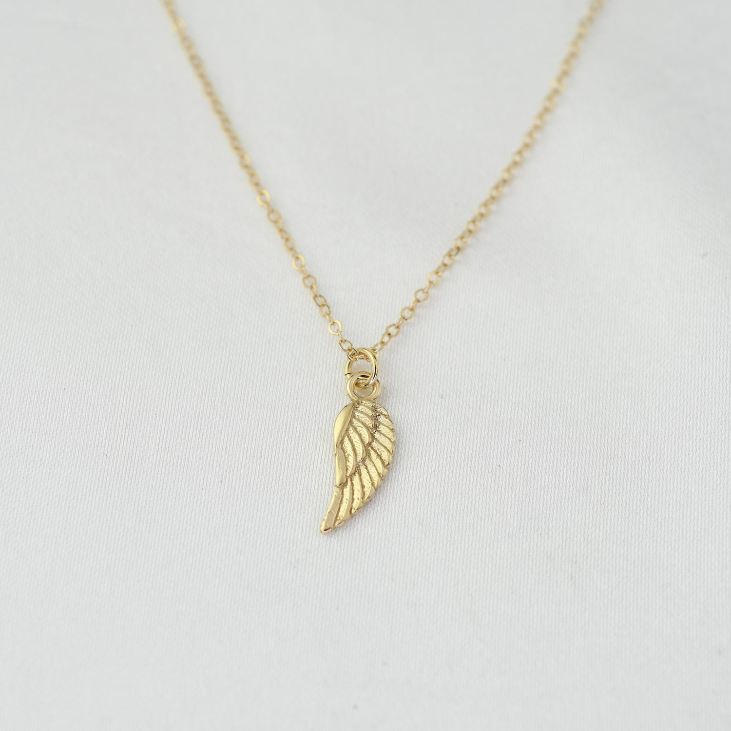 14K solid gold angel wing necklace by Sash Jewelry, featuring detailed feather design and elegant chain.