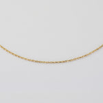 A delicate gold chain necklace displayed in a gentle curve against a plain white background.