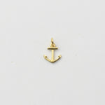 A small gold anchor charm with a top loop, shown on a plain light gray background.