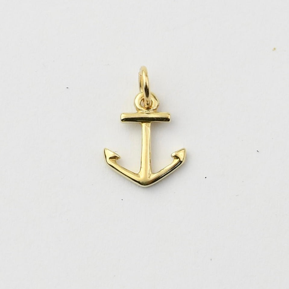A small gold anchor charm pendant with a polished finish, shown on a plain white background.