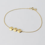 Personalized 14K solid gold initial disc bracelet by Sash Jewelry with a delicate chain and engraved initial pendant.