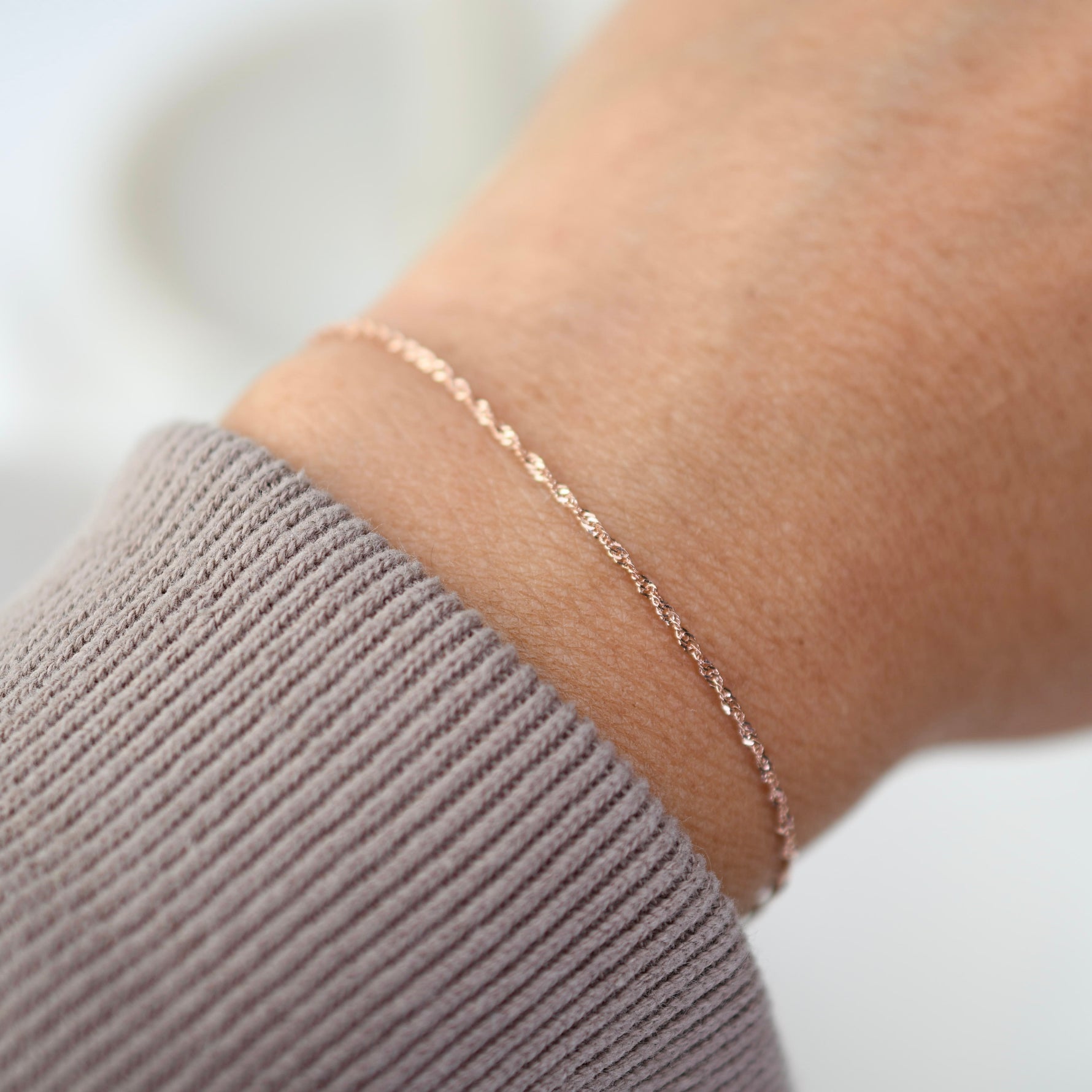 Minimal 14K gold Singapore chain bracelet worn on wrist