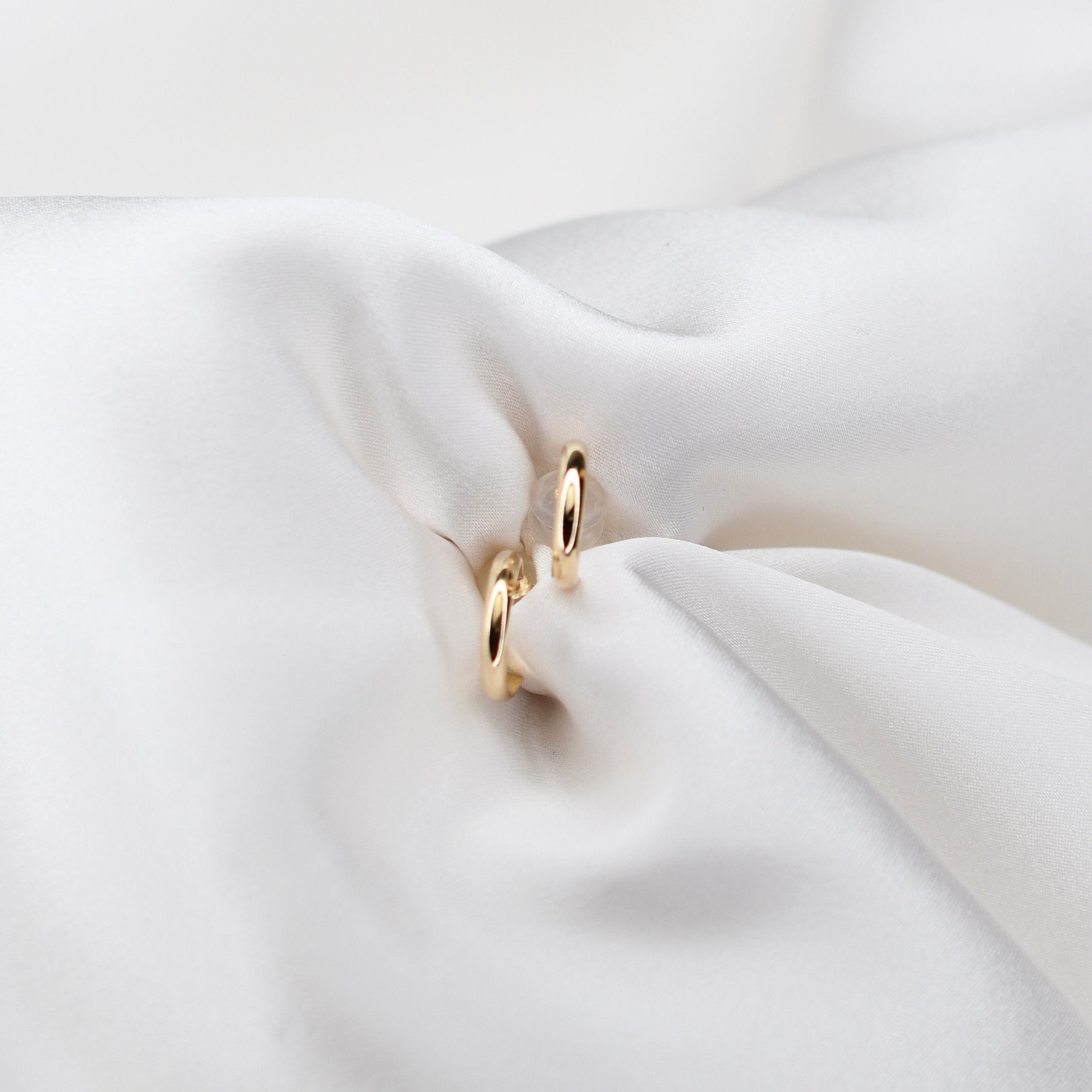 14K gold hoop earrings by Sash Jewelry, minimalist solid gold design, perfect for everyday wear, shown in close-up image.