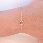 Rose gold bracelet on a wrist with a plain background