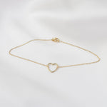 Minimal 14K yellow gold heart anklet close up
