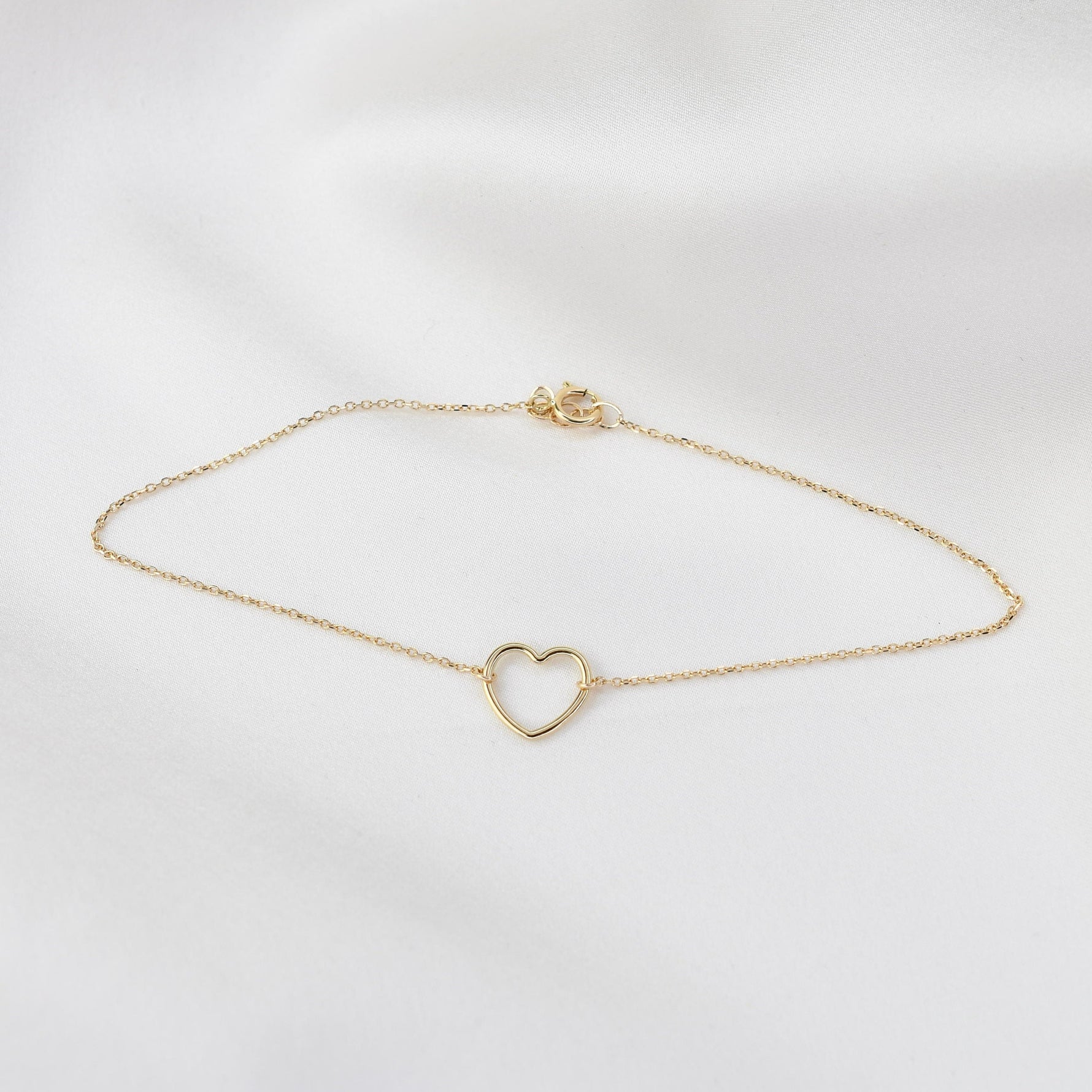 Minimal 14K yellow gold heart anklet close up
