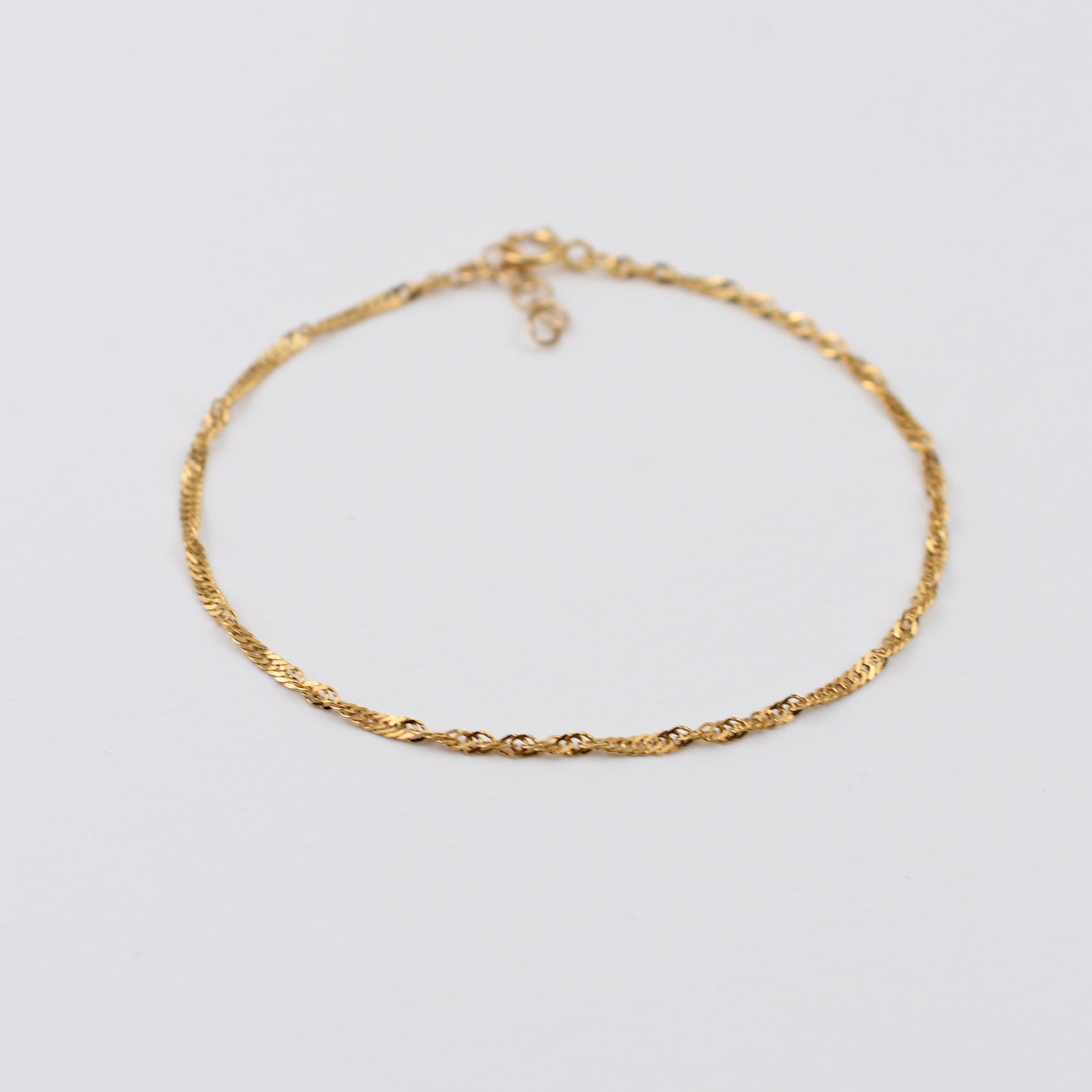 Gold chain necklace on a light gray background