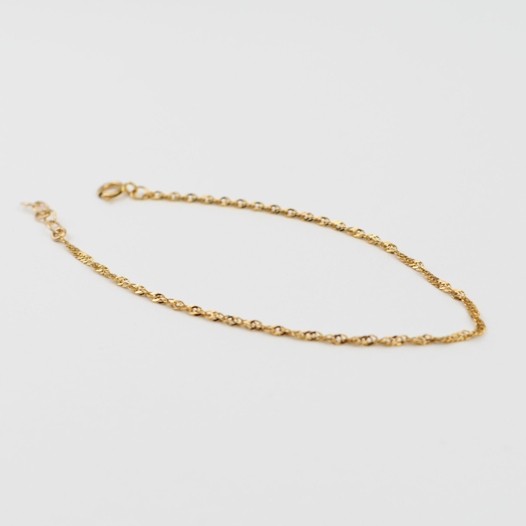 Gold chain on a light gray background