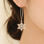 Close-up of a person wearing a snowflake earring with a soft focus on the background