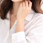 Woman with light makeup and a white shirt on a plain background