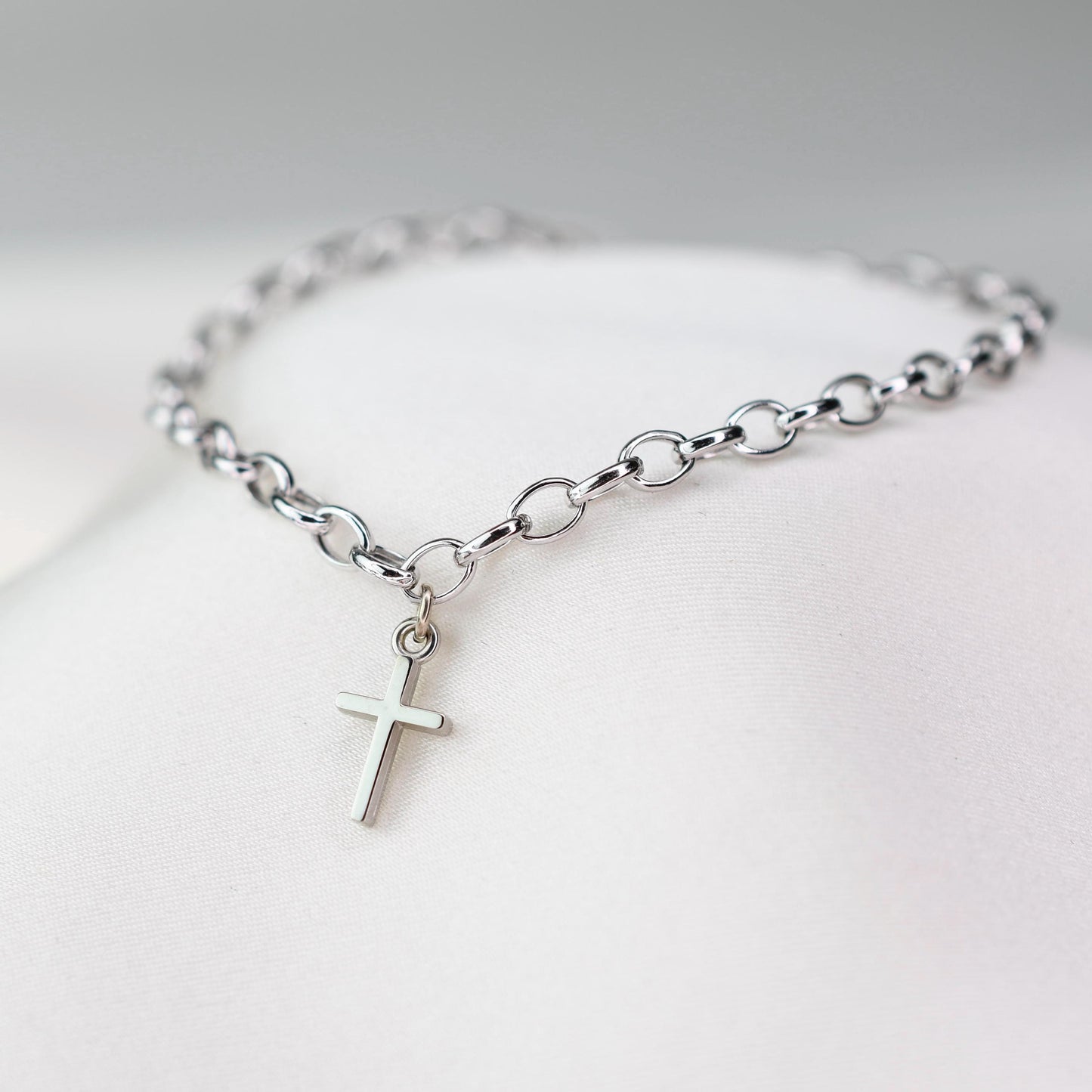 This elegant 14K white gold cross bracelet features a delicate 3.2mm rolo chain and a small cross charm, creating a timeless piece that symbolizes faith and style.