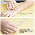 Instructions for measuring wrist size with a string and ruler on a yellow surface.