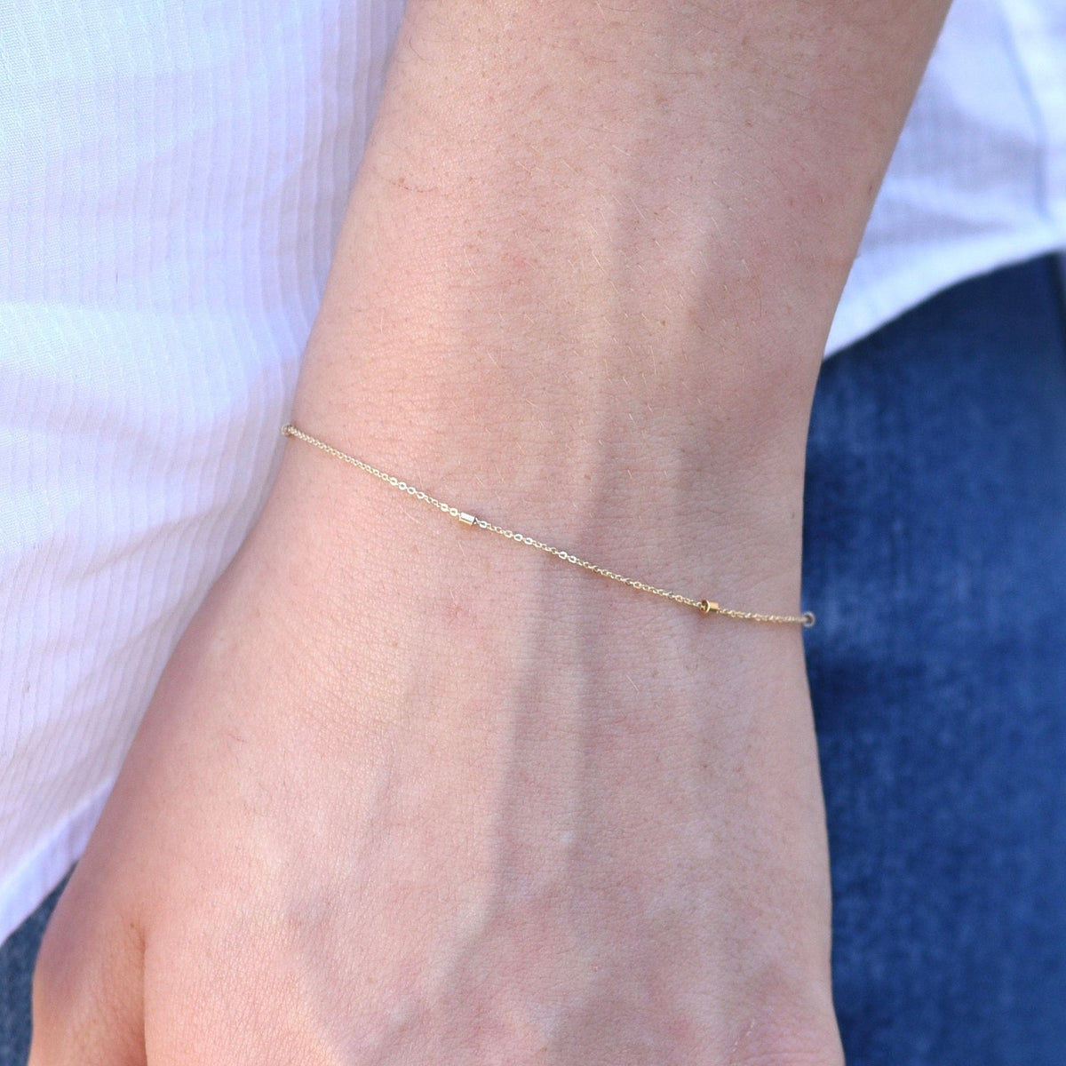 14K gold dainty chain bracelet with 1.5mm beads from Sash Jewelry, featuring a delicate, thin gold chain design.