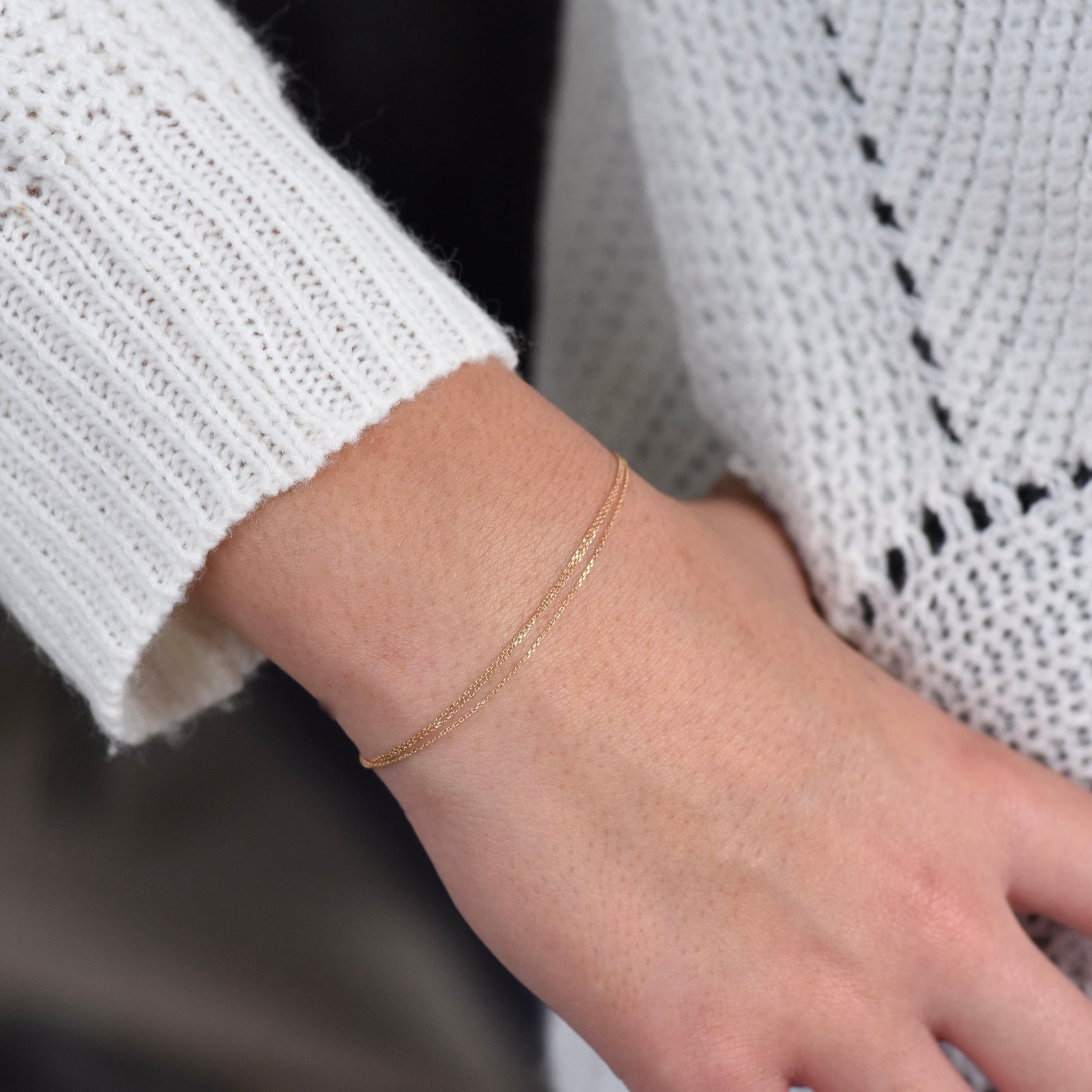 Gold bracelet on a wrist with a blurred background