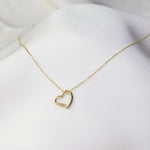 Minimal 14K gold heart charm necklace close up